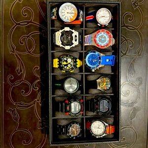 A box of various watches, ranging from G-Shock to Swatch to Kyboe to Fossil.